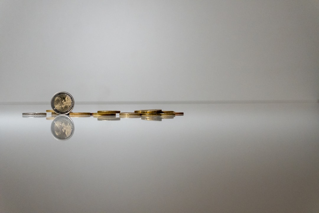 a-group-of-coins-sitting-on-top-of-a-reflective-surface-olxb-wnjrqk